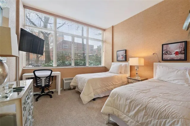 a bedroom with two beds and a large window