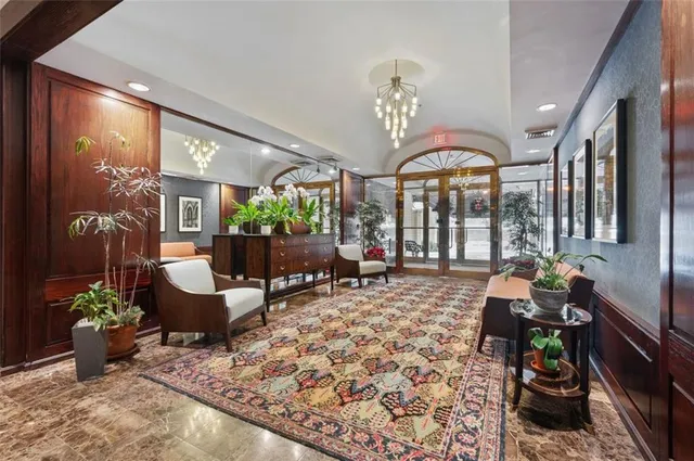 a living room with furniture chandelier and a large window