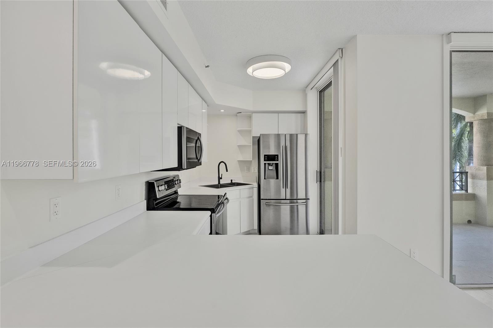 1834 Brickell Avenue, Unit 31 Miami, FL 33129 - Photo 4 of 35 a large white kitchen with cabinets and stainless steel appliances