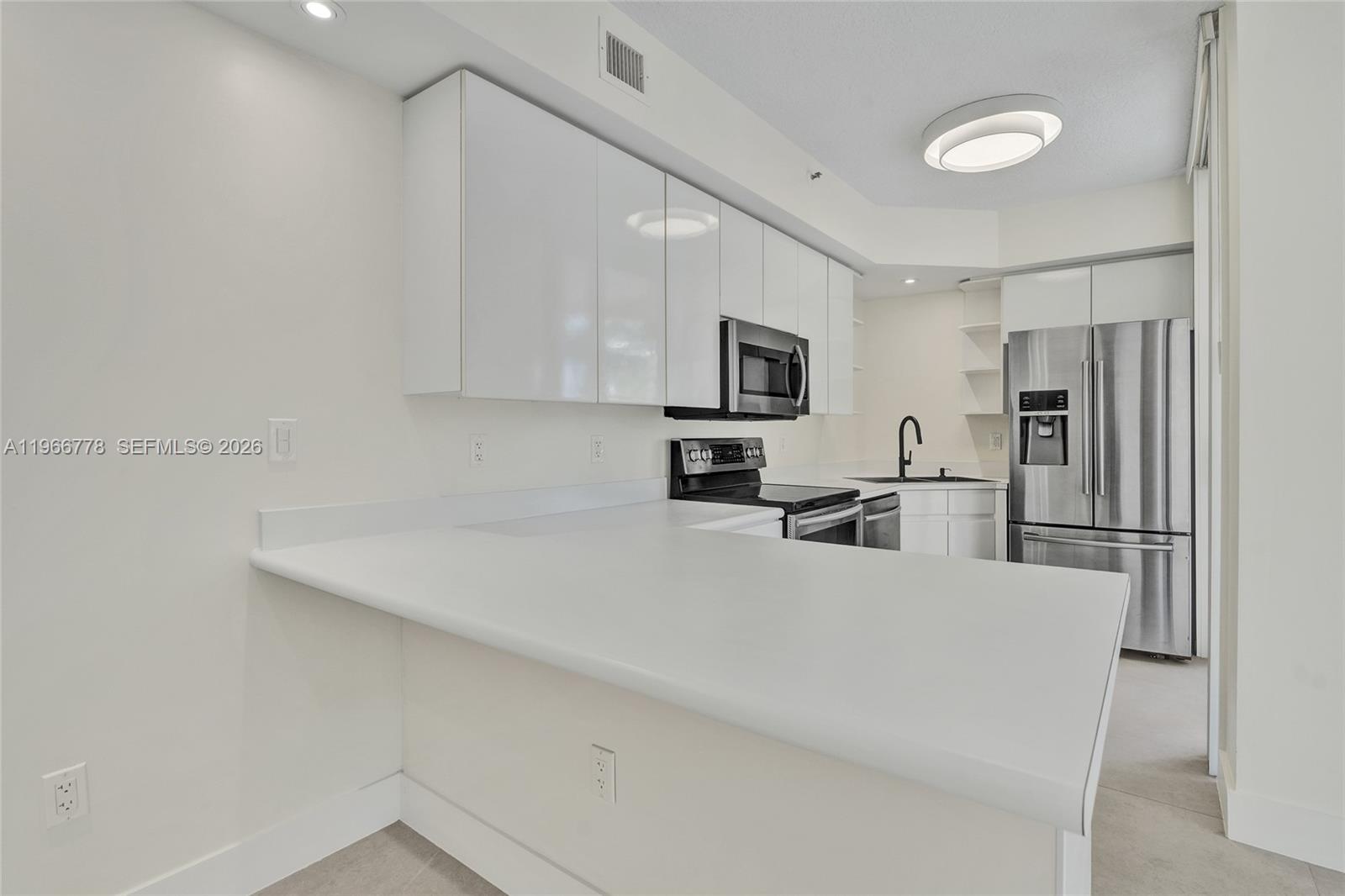 1834 Brickell Avenue, Unit 31 Miami, FL 33129 - Photo 5 of 35 a kitchen with a refrigerator a microwave a stove cabinets and a counter top space