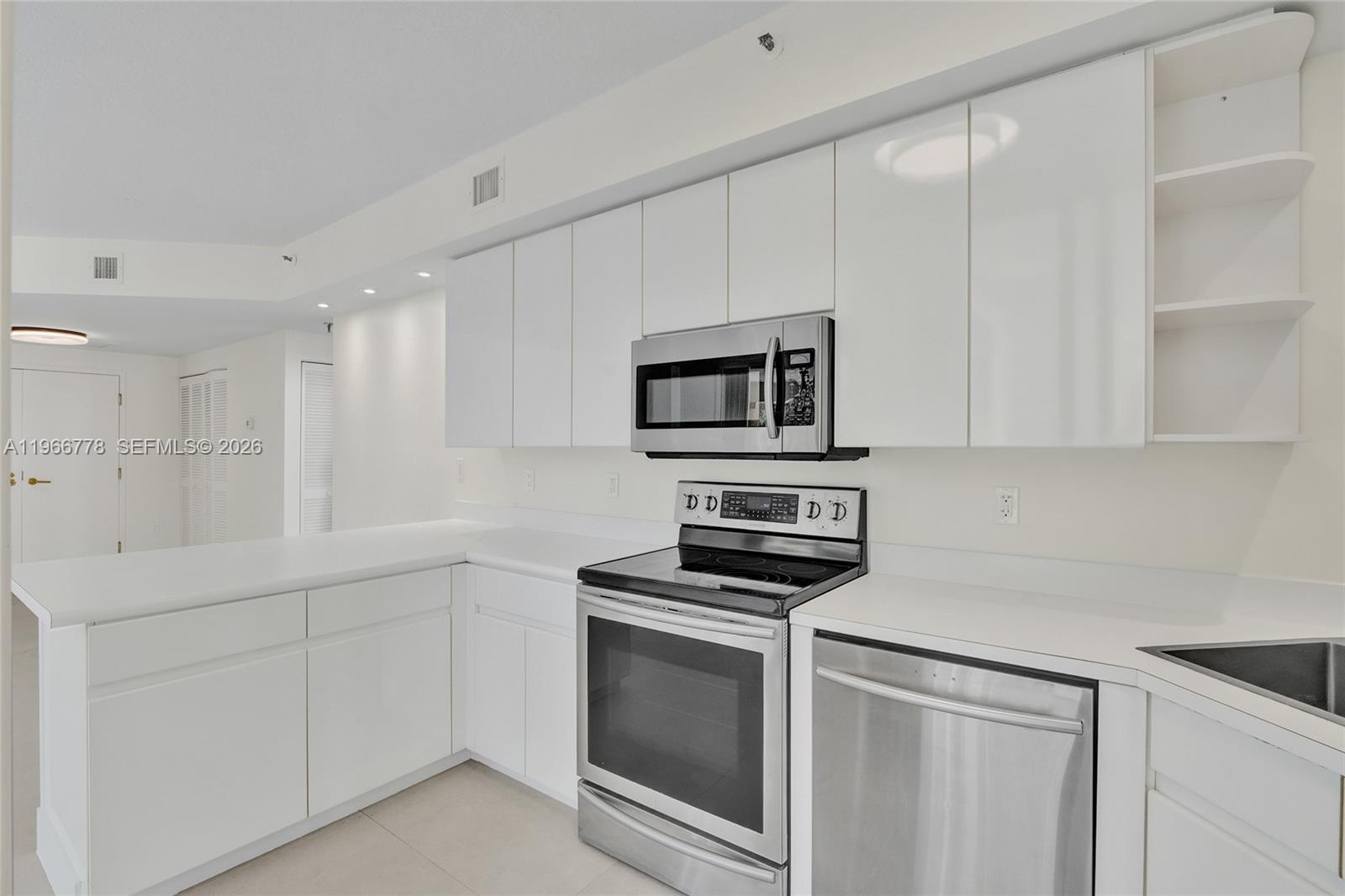 1834 Brickell Avenue, Unit 31 Miami, FL 33129 - Photo 6 of 35 a kitchen with white cabinets stainless steel appliances and sink