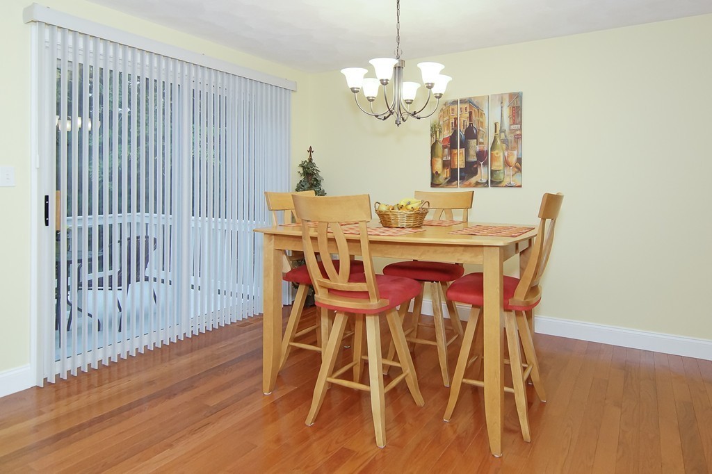81 Salem Road, Unit 101 Billerica, MA 01821 - Photo 13 of 30 a view of a dining room with furniture wooden floor and chandelier