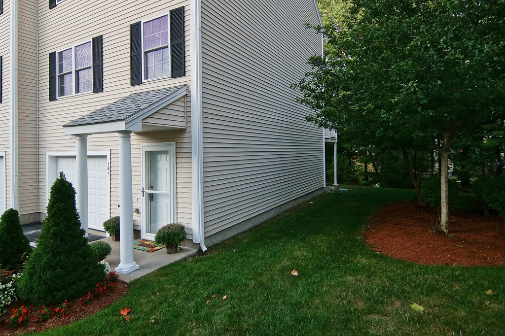 81 Salem Road, Unit 101 Billerica, MA 01821 - Photo 4 of 30 a view of a house with backyard and a tree