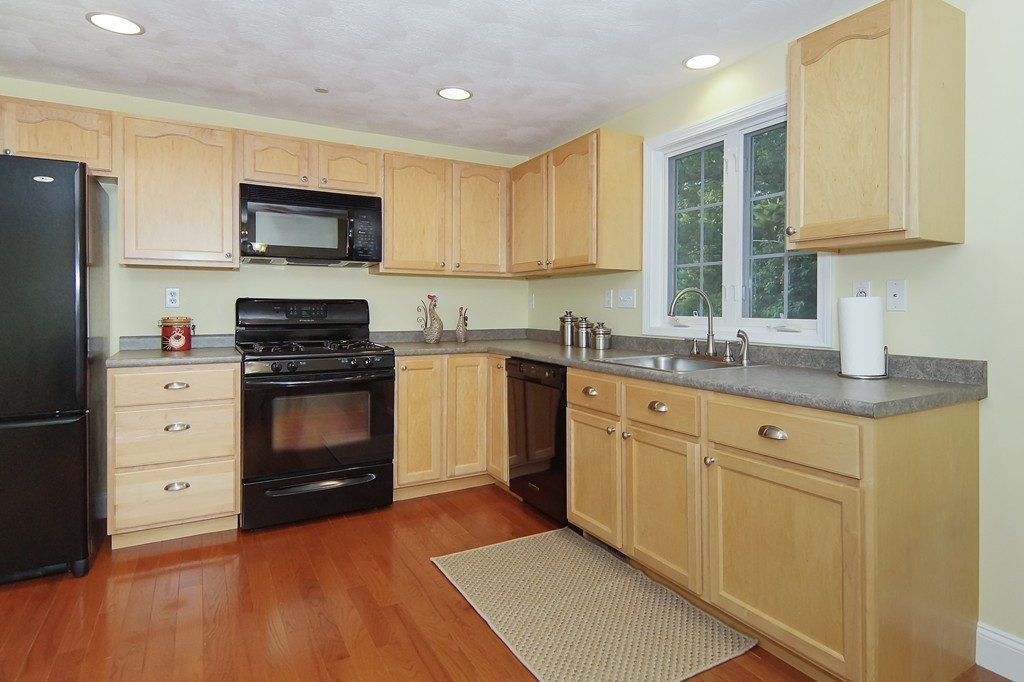 81 Salem Road, Unit 101 Billerica, MA 01821 - Photo 9 of 30 a kitchen with stainless steel appliances a stove sink and cabinets