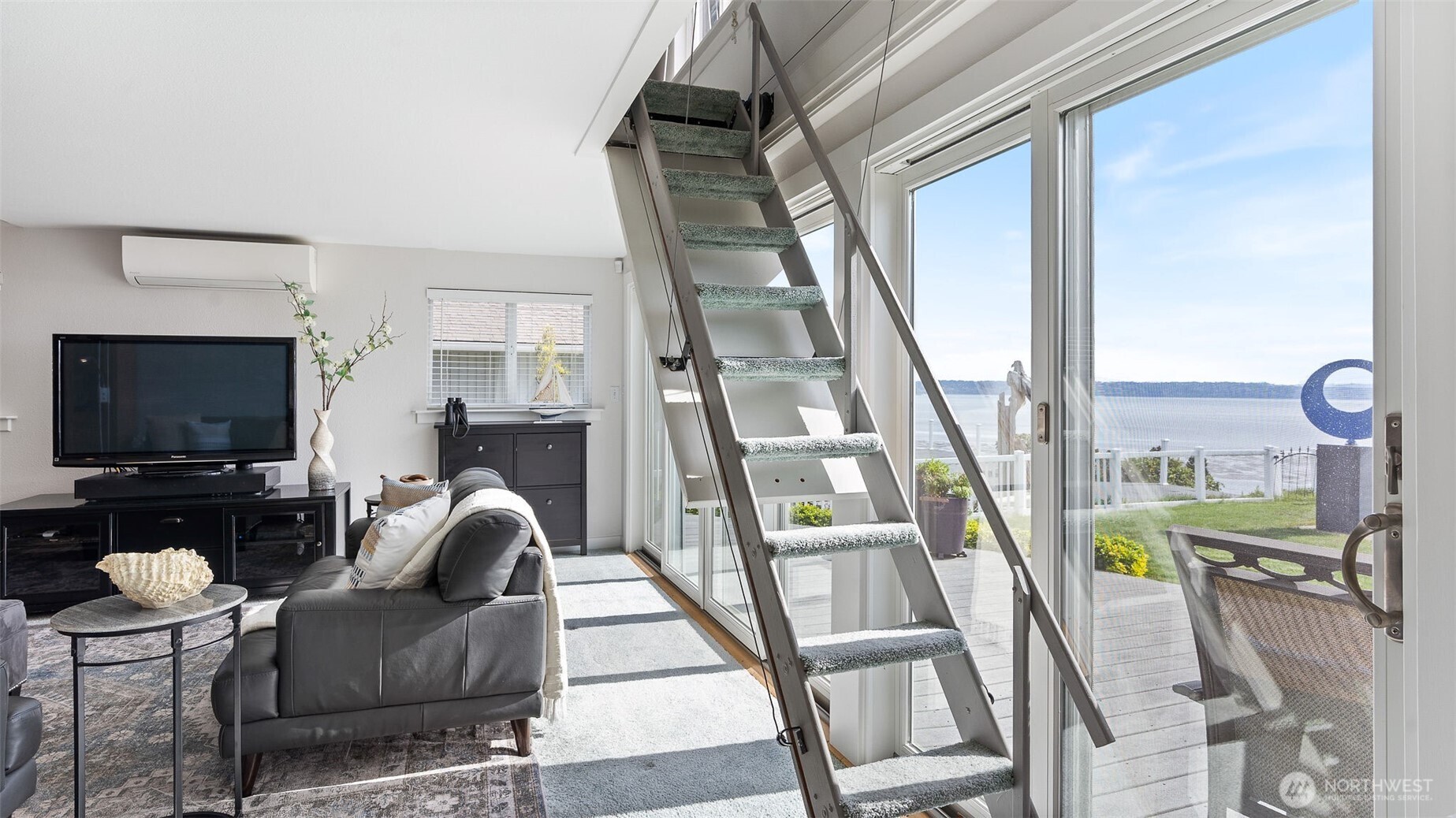 1406 Potlatch Beach Road Marysville, WA 98271 - Photo 24 of 40 a living room with furniture a flat screen tv and a floor to ceiling window