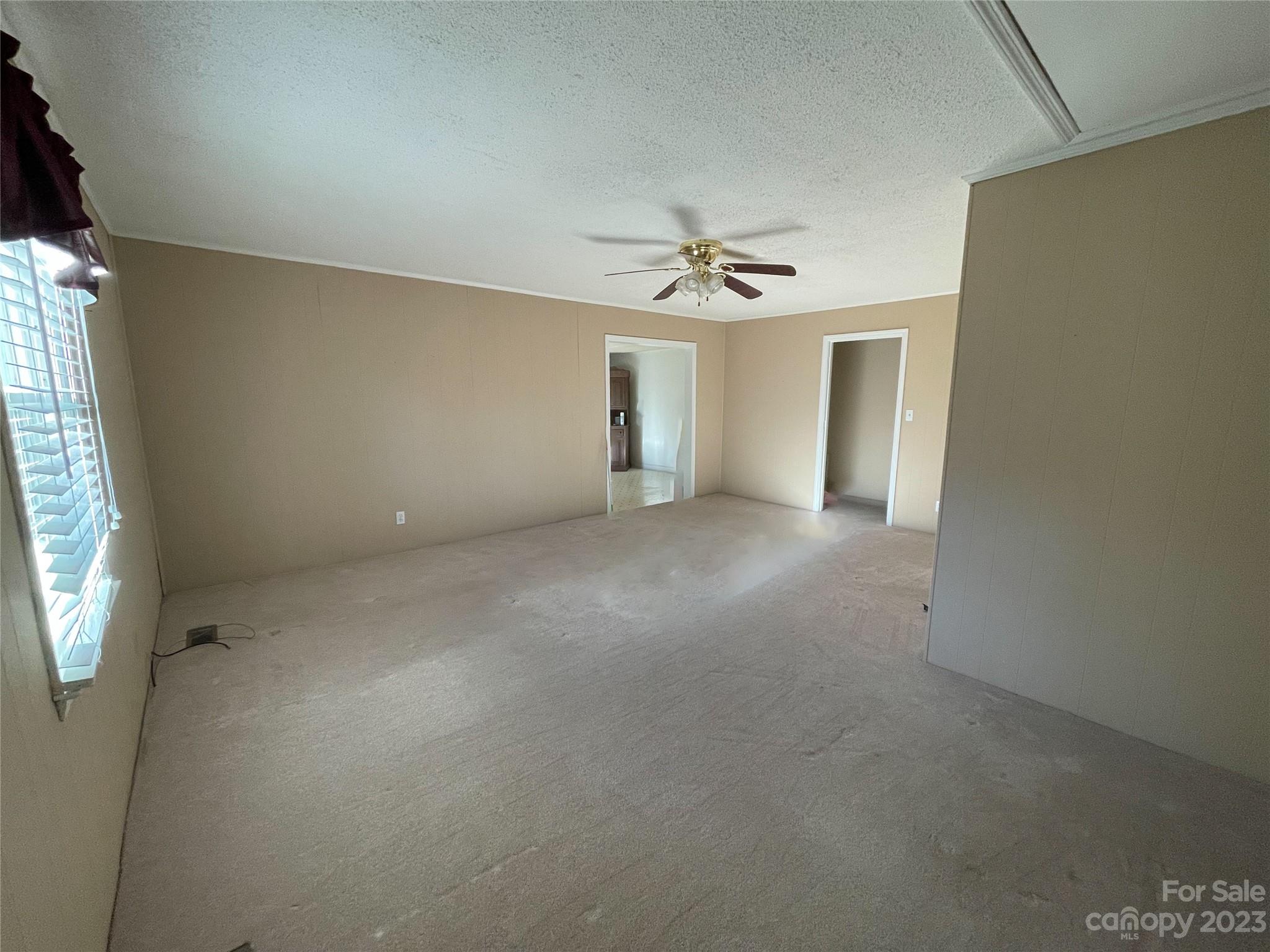 406 Fair Street Bethune, SC 29009 - Photo 8 of 28 en empty room with windows and ceiling fan