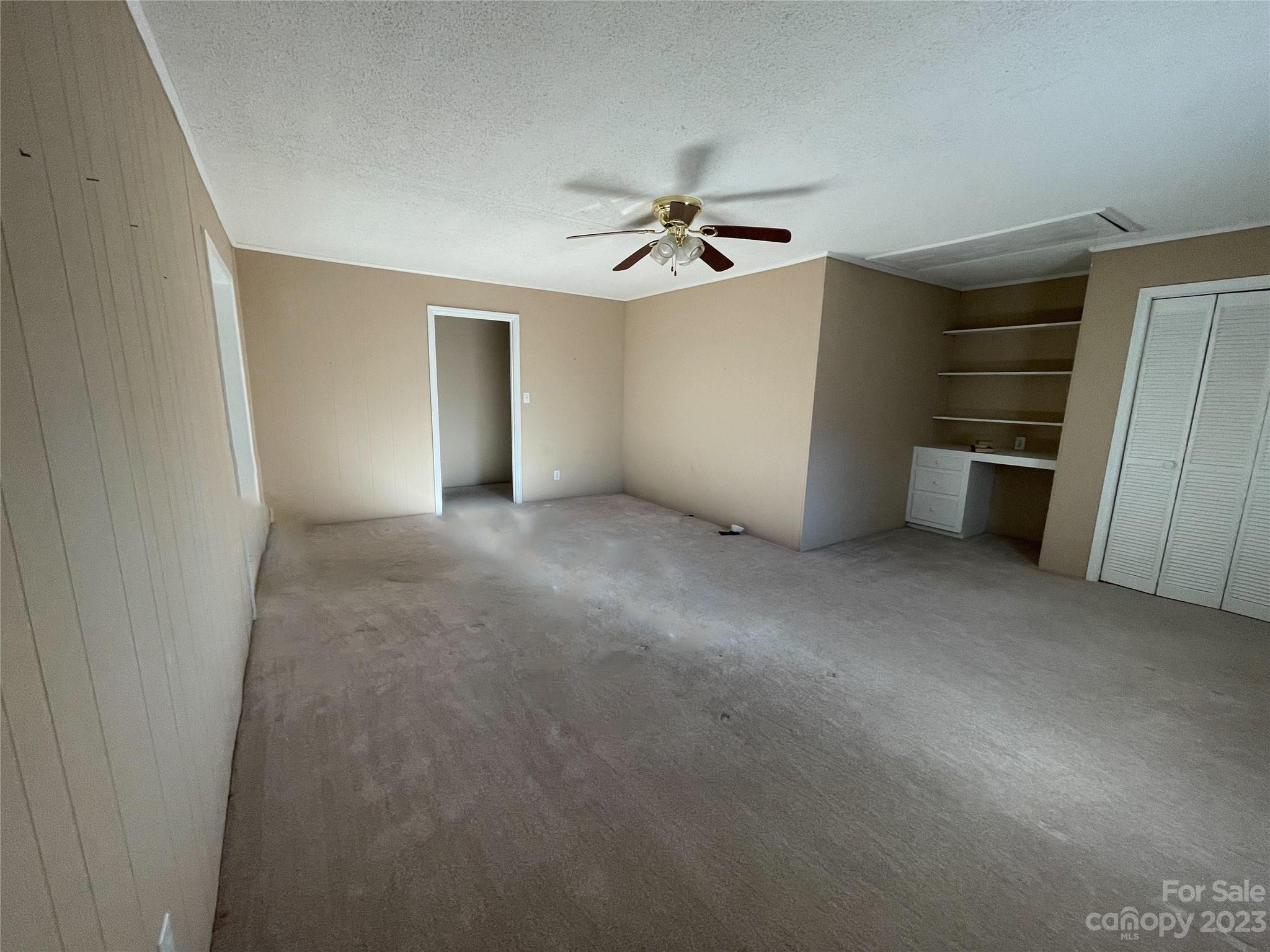 406 Fair Street Bethune, SC 29009 - Photo 9 of 28 an empty room with a ceiling fan and entryway