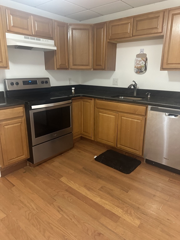 115-117 Stone Street, Unit 1 Clinton, MA 01510 - Photo 2 of 8 a kitchen with granite countertop a stove and cabinets