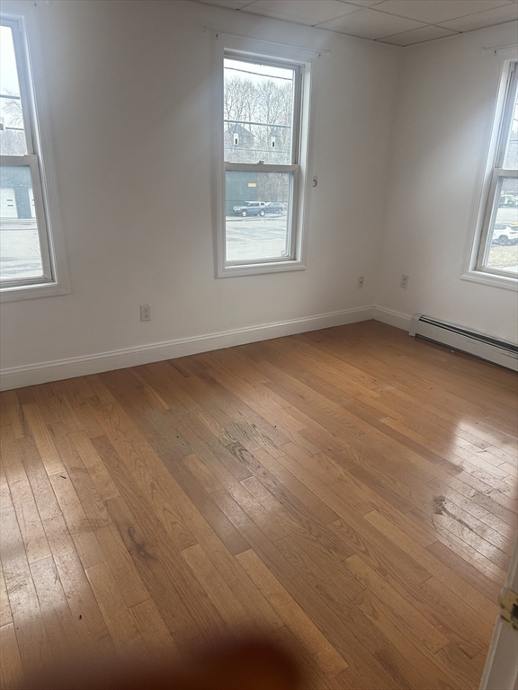 115-117 Stone Street, Unit 1 Clinton, MA 01510 - Photo 6 of 8 an empty room with wooden floor and windows