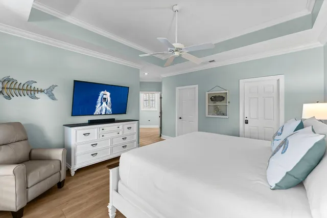 a bedroom with a bed chandelier dresser and a window