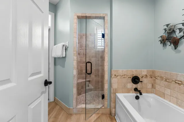 a bathroom with a tub a sink and glass door