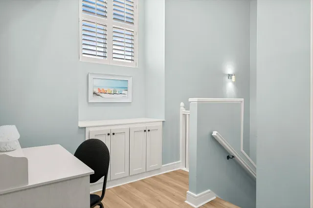 a view of a workspace with furniture and a window