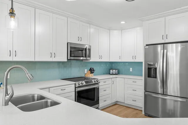 a kitchen with stainless steel appliances granite countertop a sink stove and refrigerator