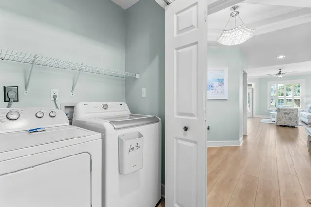 a view of washer and dryer with bathroom in the background