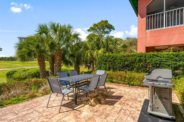 a view of a backyard with chairs potted plants and a large tree