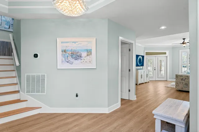 a view of a hallway with wooden floor and a living room