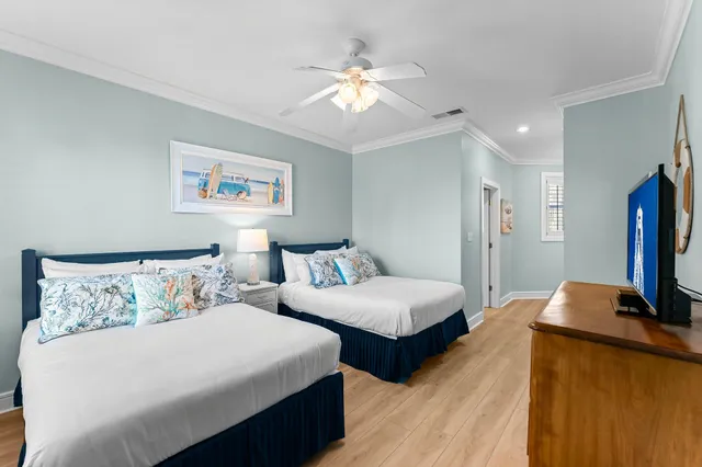 a bedroom with two beds and a flat screen tv