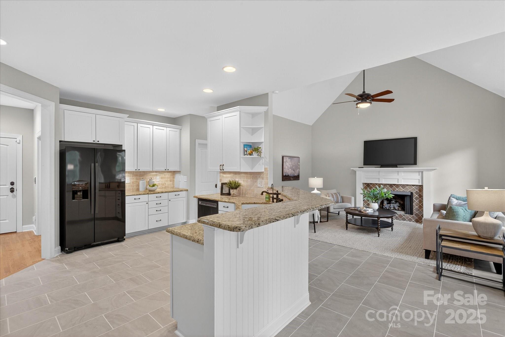 1912 Windmere Drive Monroe, NC 28110 - Photo 7 of 37 a living room with stainless steel appliances kitchen island furniture and a flat screen tv