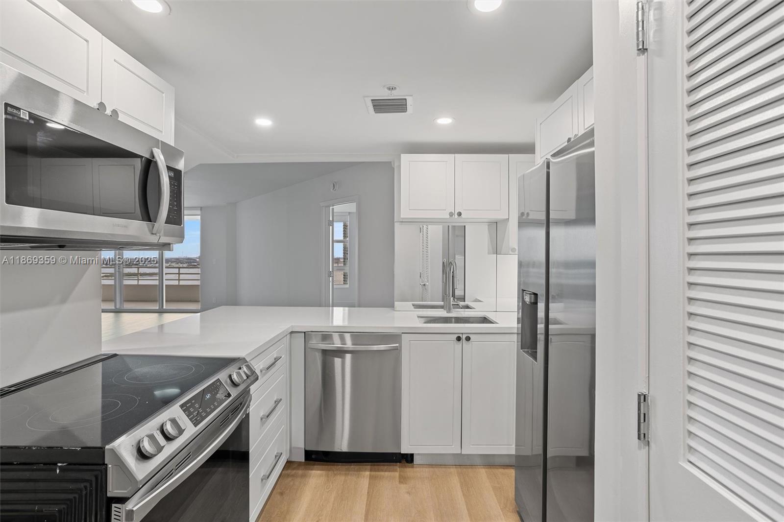 a kitchen with stainless steel appliances granite countertop a stove a sink and a refrigerator