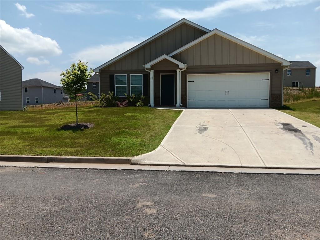 a view of a white house with a yard and a large tree