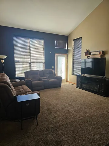 a living room with furniture a flat screen tv and a window