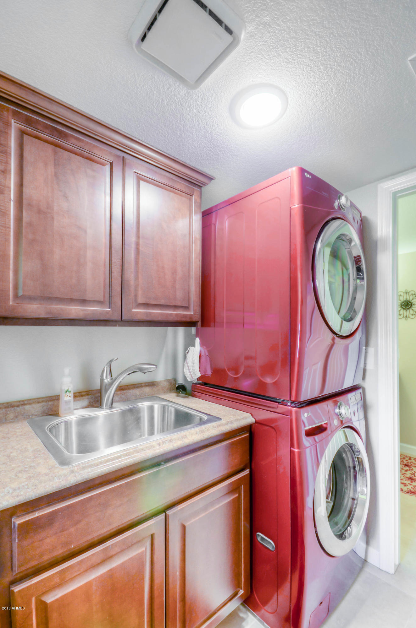 1433 North Woodside Road Chandler, AZ 85224 - Photo 30 of 70 a kitchen with stainless steel appliances granite countertop a sink a washer and dryer