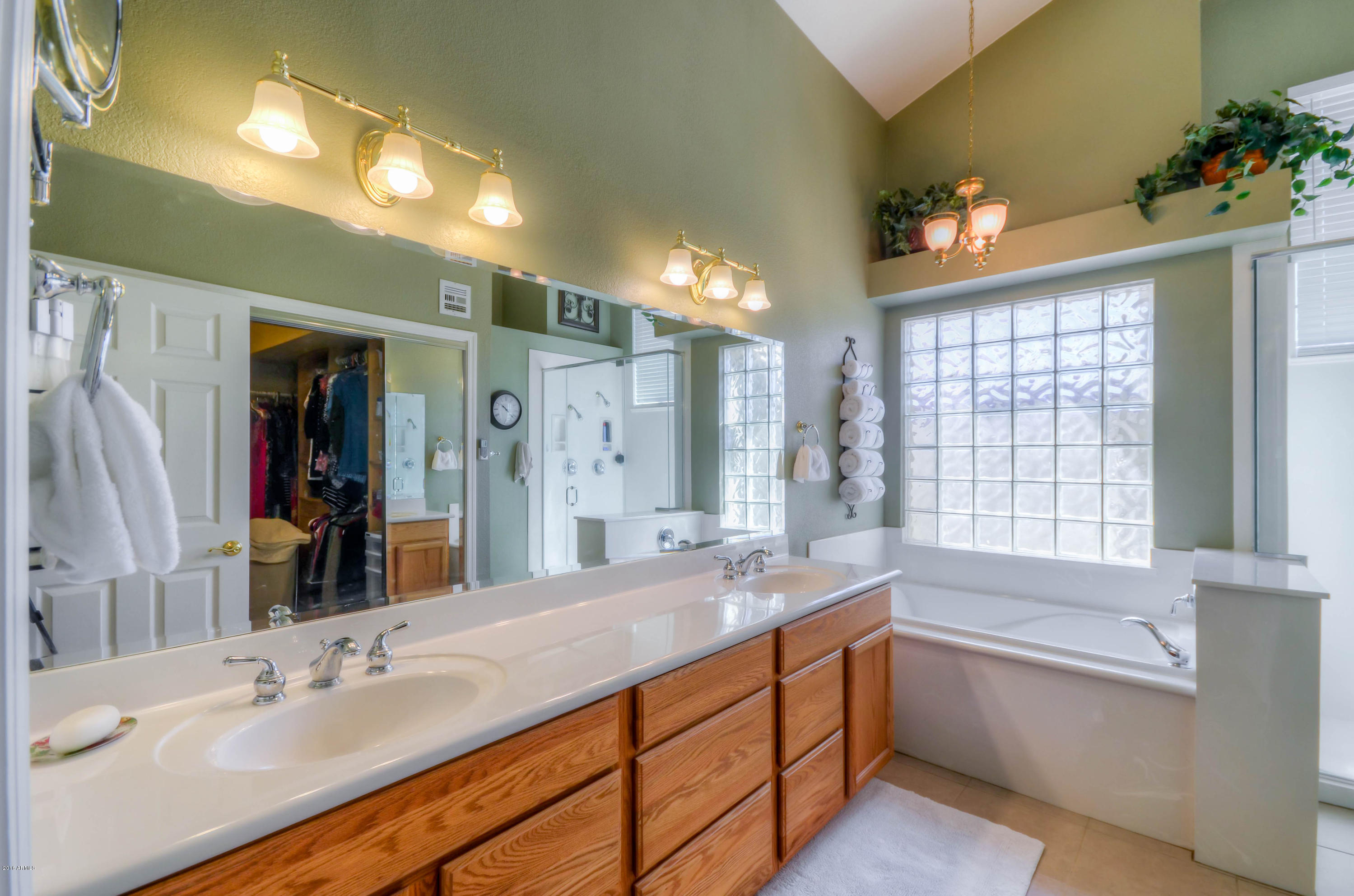 1433 North Woodside Road Chandler, AZ 85224 - Photo 38 of 70 a bathroom with a double vanity sink a large mirror and a bathtub