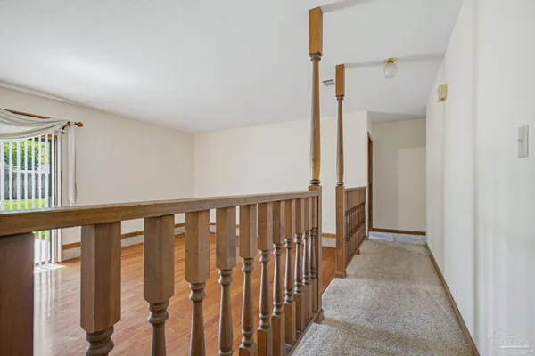 an empty room with windows and chandelier fan