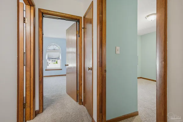 an empty room with windows and chandelier fan