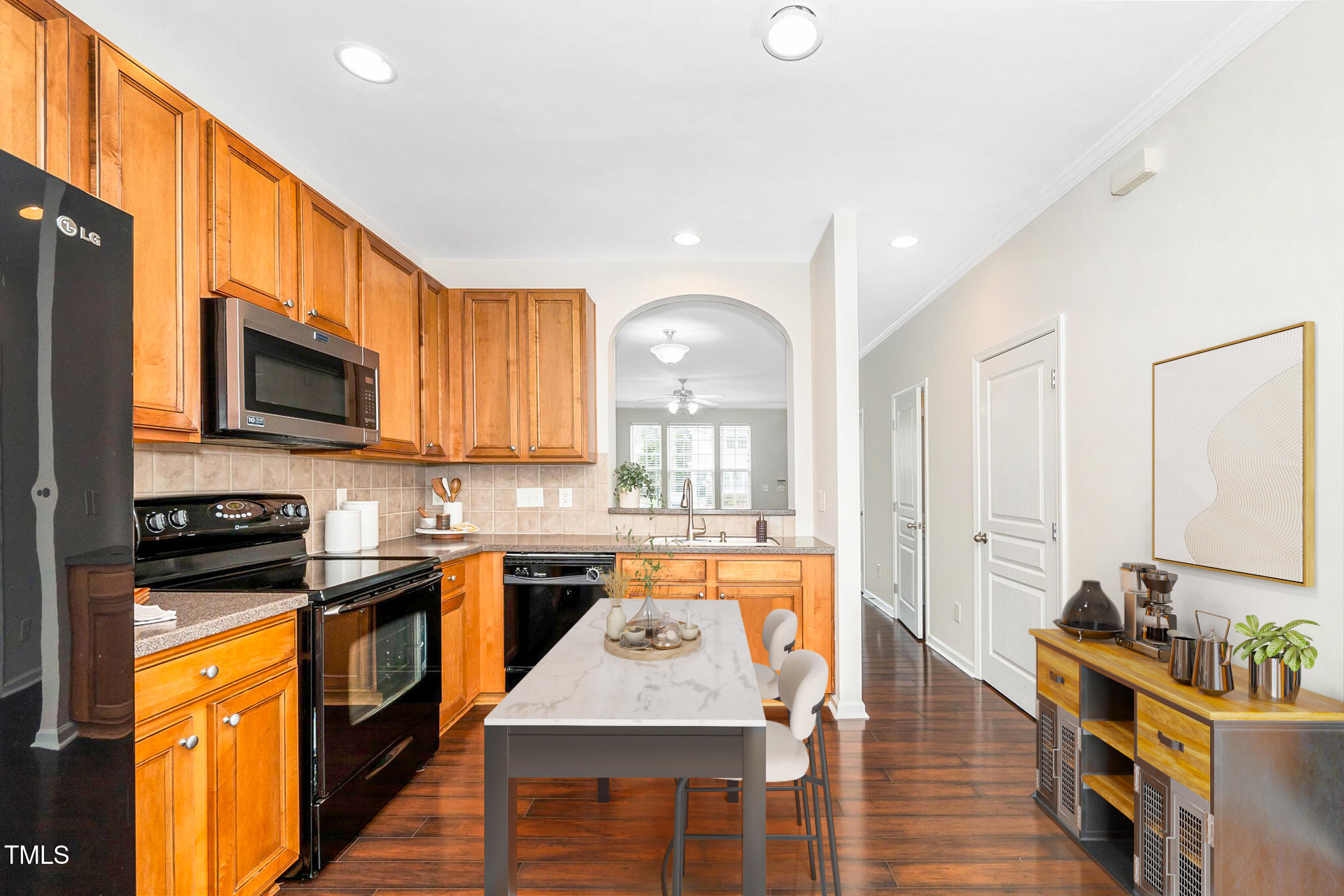 7753 Winners Edge Street Raleigh, NC 27617 - Photo 13 of 46 a large kitchen with stainless steel appliances granite countertop a stove top oven a sink dishwasher and wooden cabinets with wooden floor