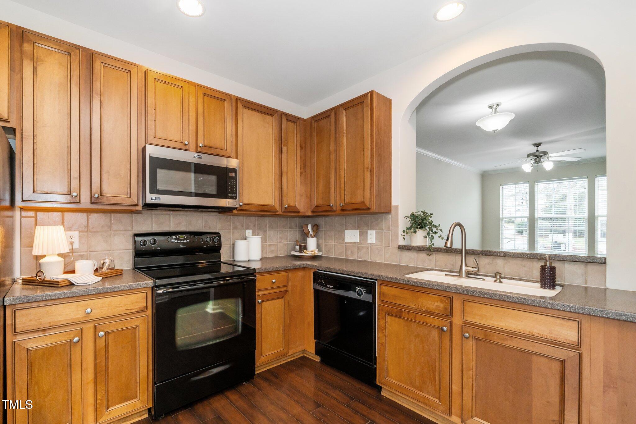 7753 Winners Edge Street Raleigh, NC 27617 - Photo 16 of 46 a kitchen with stainless steel appliances granite countertop a sink stove and microwave
