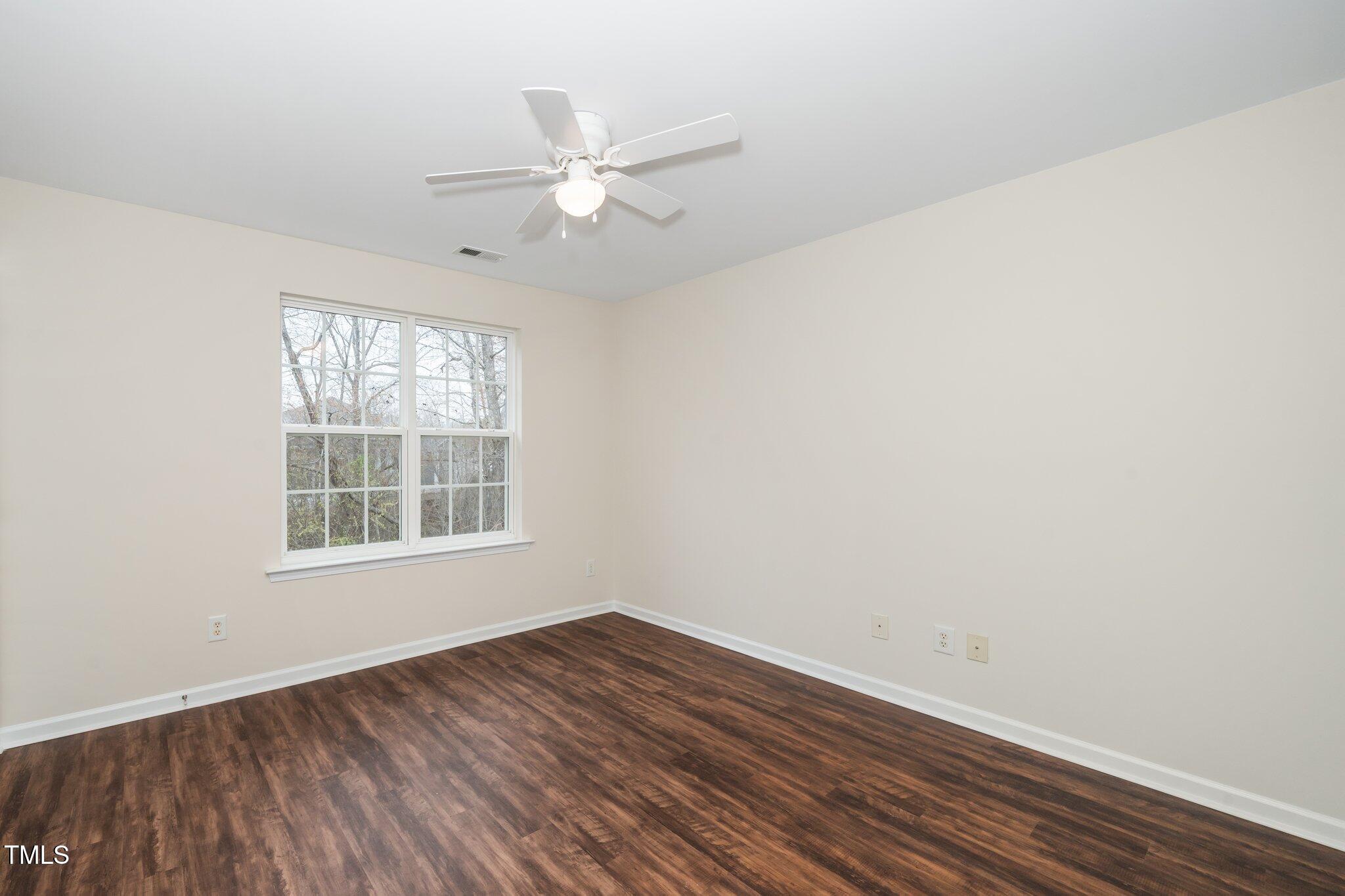 7753 Winners Edge Street Raleigh, NC 27617 - Photo 29 of 46 an empty room with wooden floor fan and windows