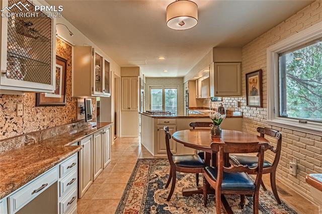 7175 Higher Ridges Court Colorado Springs, CO 80919 - Photo 14 of 50 Dining room featuring light tile patterned flooring and brick wall