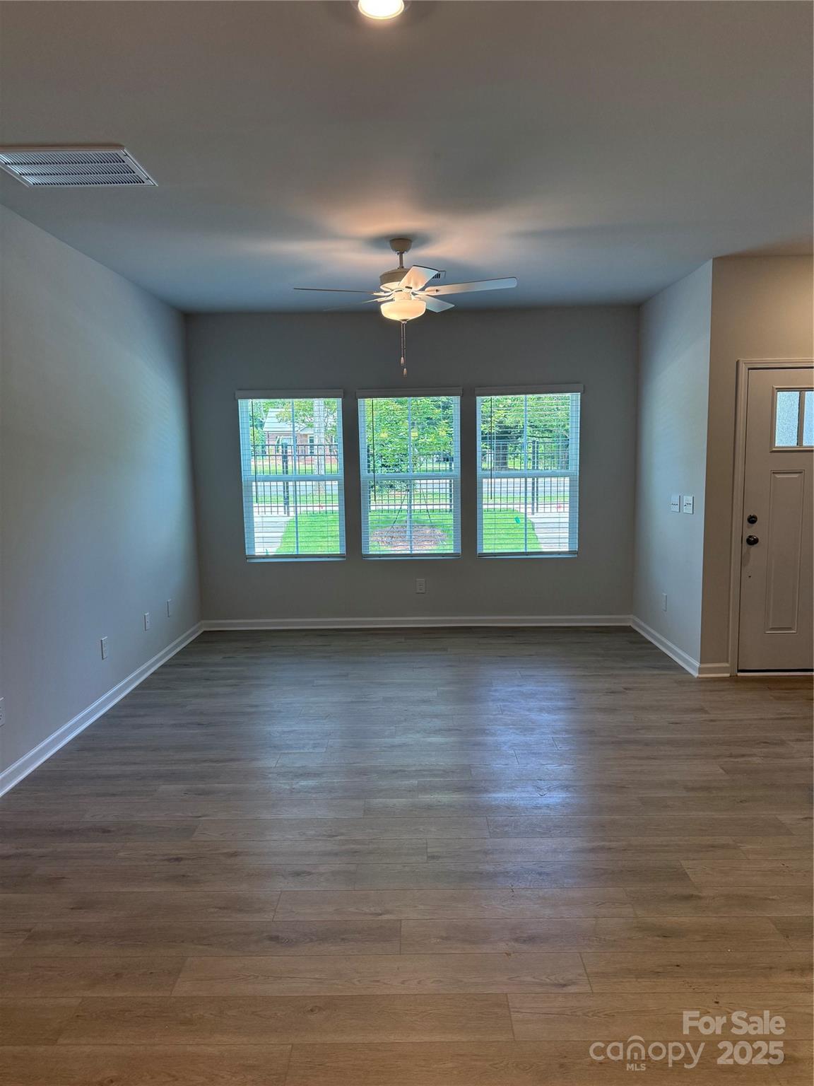 5821 Tuckaseegee Road Charlotte, NC 28208 - Photo 4 of 9 an empty room with wooden floor and windows