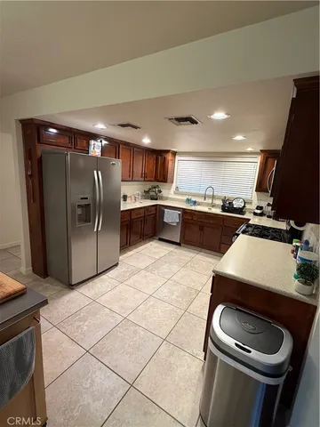 a kitchen with stainless steel appliances granite countertop a refrigerator a sink a stove a microwave and island