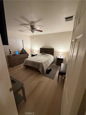 a bedroom with a bed and a flat tv screen on the dresser