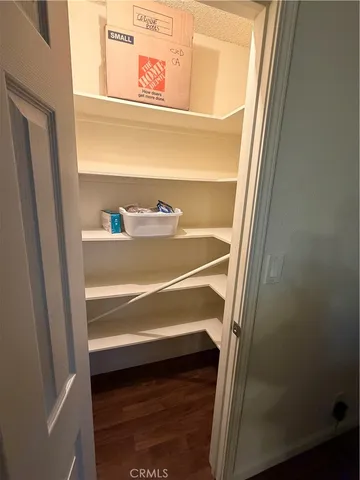 a view of a hallway with wooden floor and closet area