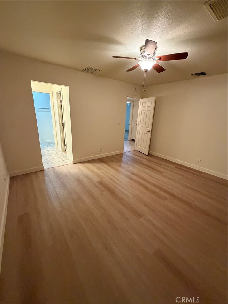 209 Kimberly Lane Ridgecrest, CA 93555 - Photo 54 of 62 an empty room with wooden floor chandelier fan and windows