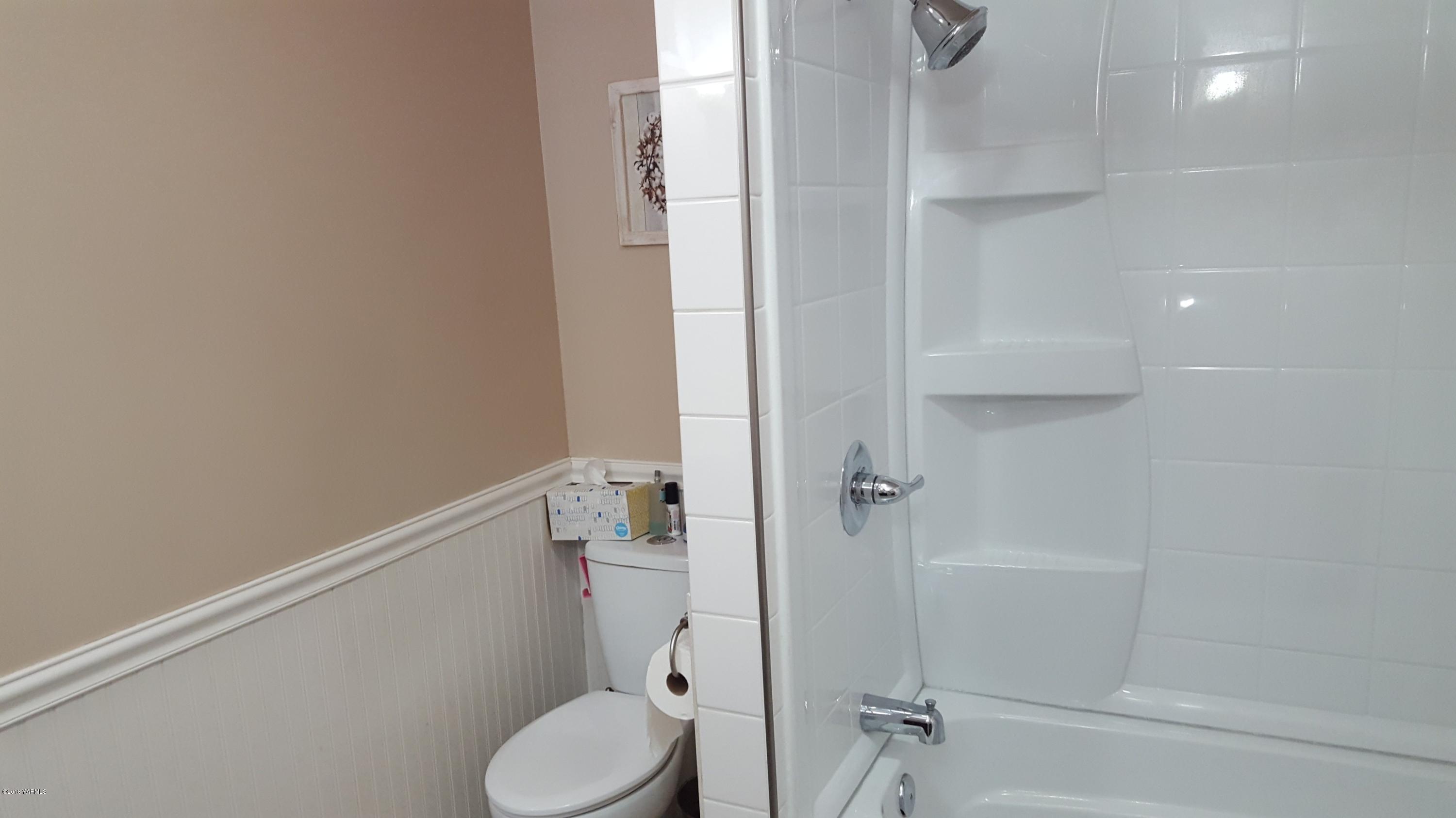 3380 Reeves Road Sunnyside, WA 98944 - Photo 16 of 32 a bathroom with a granite countertop toilet and a shower