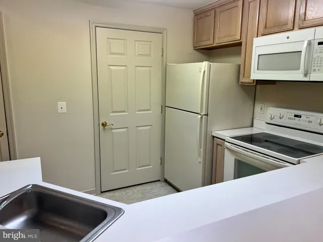 a kitchen with a refrigerator sink and cabinets