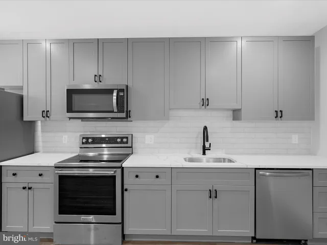 a kitchen with white cabinets and stainless steel appliances