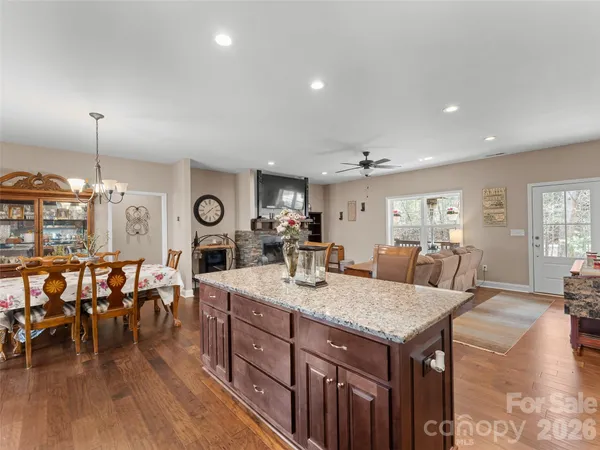 a kitchen with stainless steel appliances granite countertop a sink a stove and a microwave oven with wooden cabinets
