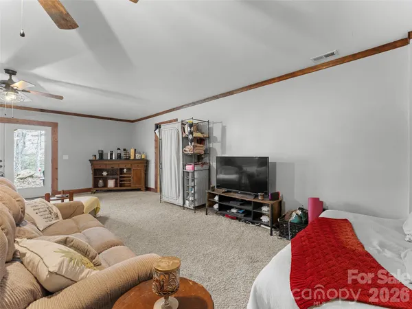 a bedroom with a bed a chandelier and a window