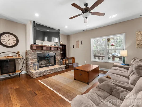 a living room with furniture kitchen view and a wooden floor