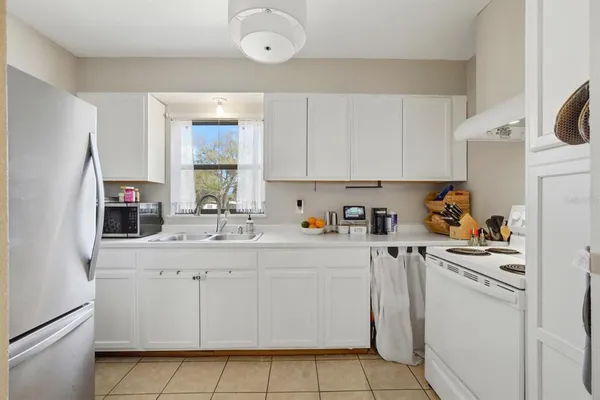 a kitchen with stainless steel appliances granite countertop white refrigerator stove and white cabinets