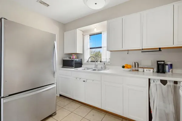 a kitchen with stainless steel appliances a stove a refrigerator cabinets and a dining table