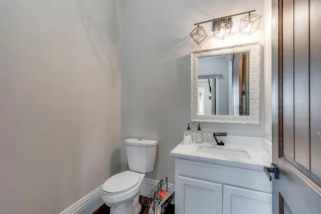 a bathroom with a sink a toilet and mirror