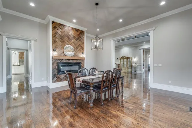 a dining room with furniture a rug a potted plant and wooden floor