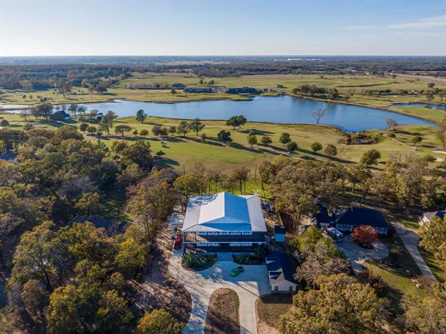 an aerial view of ocean and residential houses with outdoor space