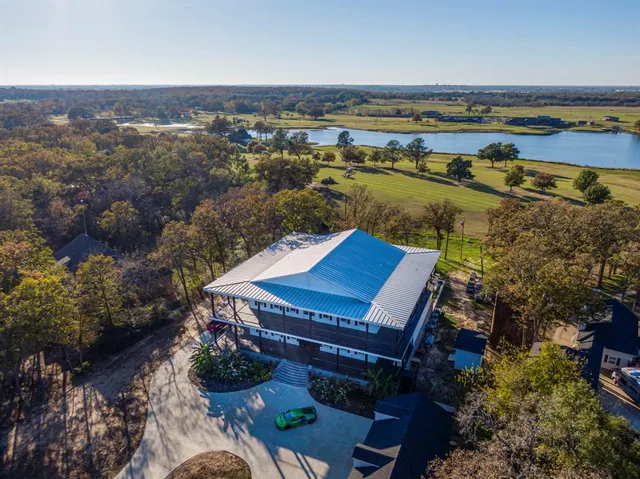 an aerial view of a house with a garden and lake view
